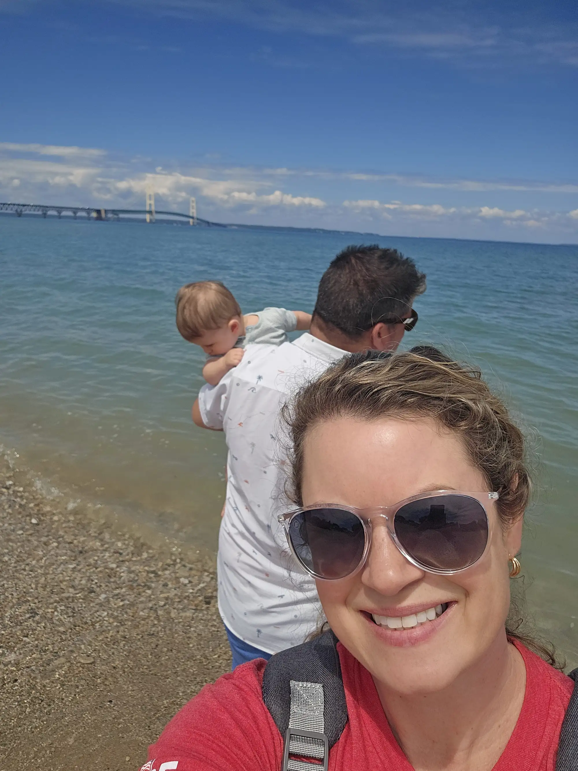 Cruz lowered into the shallows at the Straits, the Mackinac Bridge across the water behind